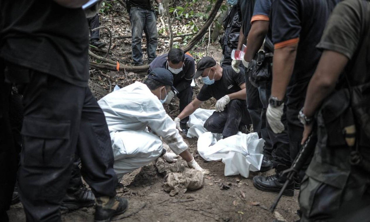 A equipe forense examina um corpo achado em uma das fossas coletivas, em Bukit Wang Burma, em uma das 139 covas encontradas Foto: Mohd Rasfan / AFP