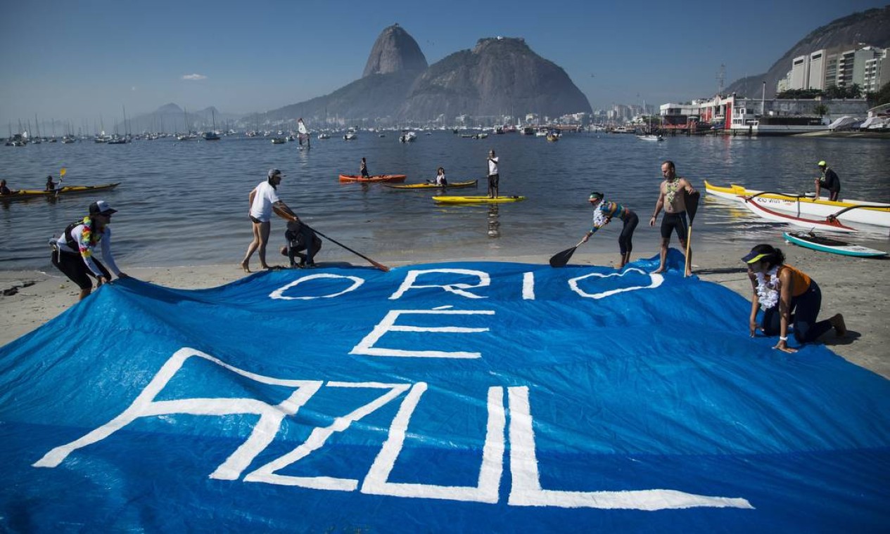 Ativistas estendem cartaz na areia da Praia de Botafogo Foto: Fernando Lemos / Agência O Globo