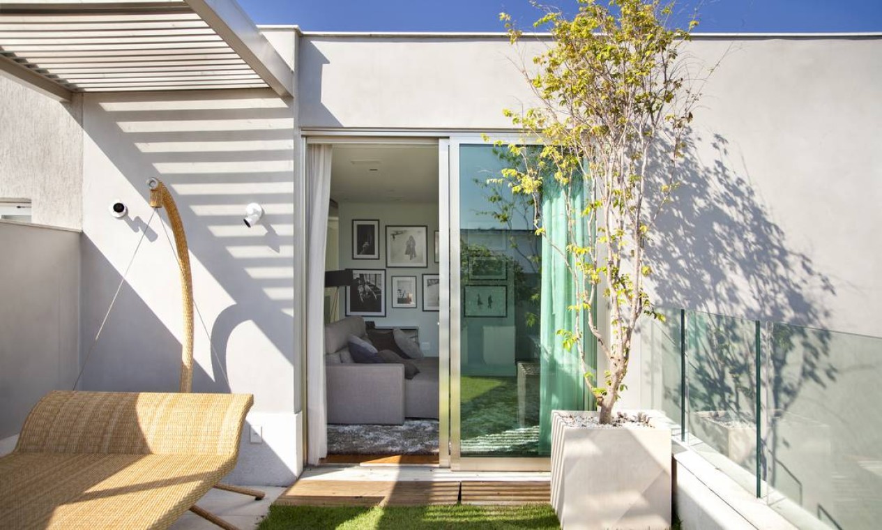 Minimalismo nos móveis da varanda. A grama dá uma cara de casa ao apartamento Foto: MCA Studio