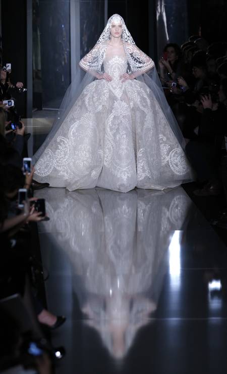 Apesar de bem dramática, a noiva do estilista Elie Saab não quis saber de muitas ousadias. O vestido é longo e claro Foto: Christophe Ena / AP