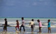 Na praia, crianças brincam no mar de Zanzibar, na Tanzânia