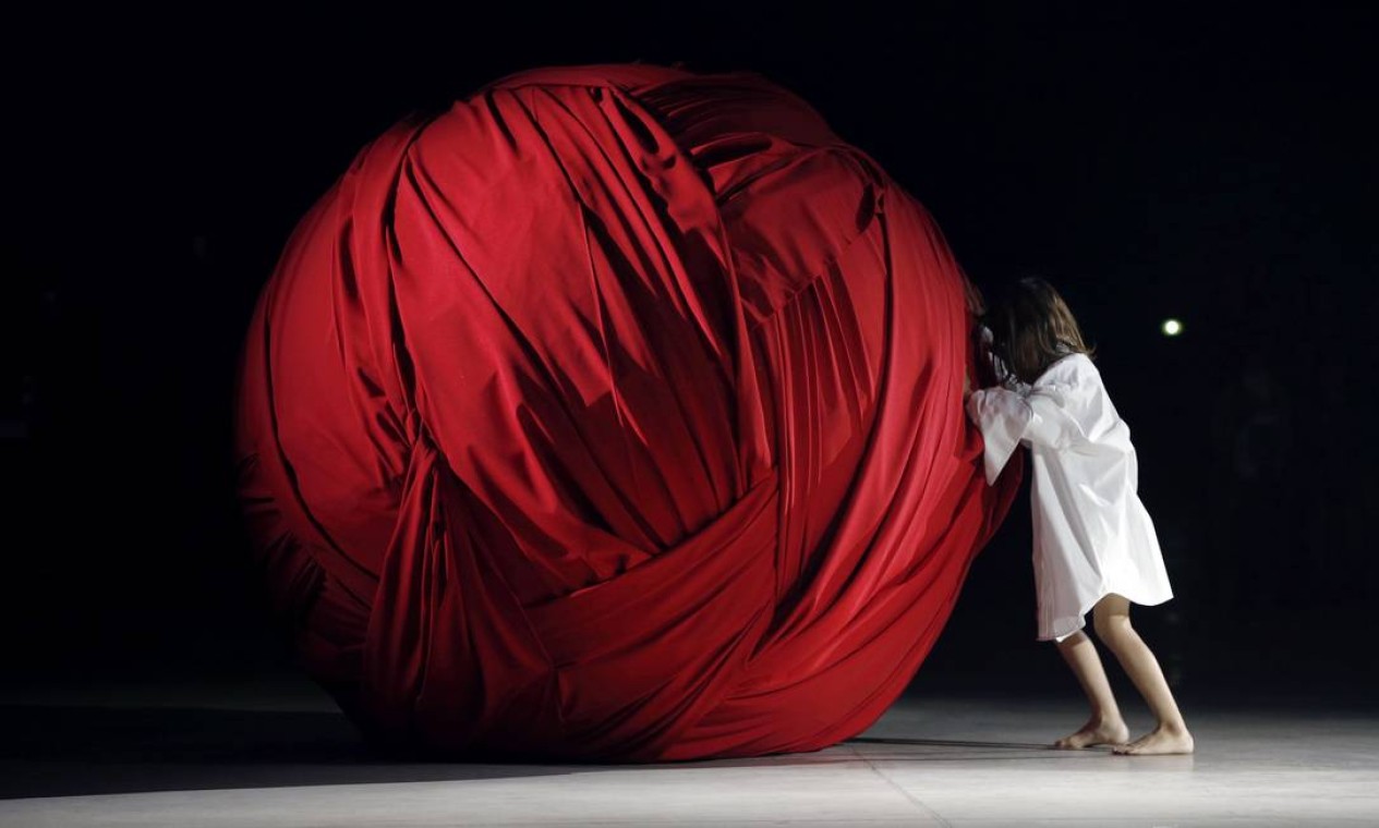 Em outro momento do desfile da Jacquemus uma menina empurrou uma bola gigantesca de tecido Foto: FRANCOIS GUILLOT / AFP