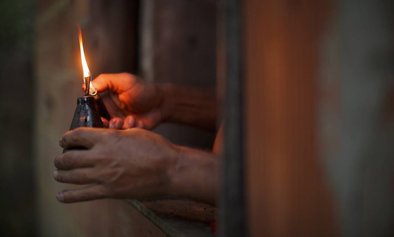 O paraibano José de Araújo, de 50 anos, acende sua lamparina de querosene no cair da noite Foto: Daniel Marenco / Agência O Globo