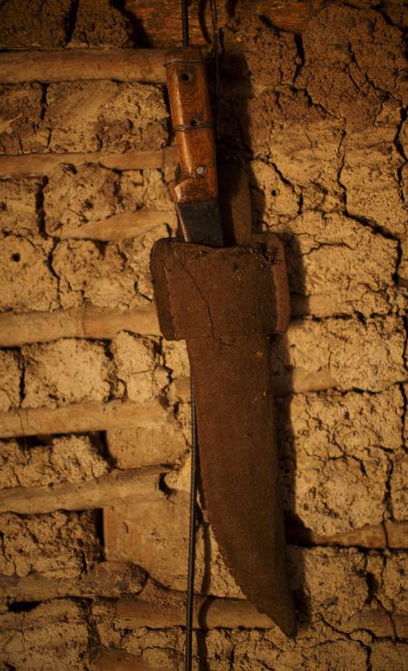 Facão, ferramenta de trabalho, pendurado na parede da casa de estuque de seu Dino Foto: Daniel Marenco / Agência O Globo