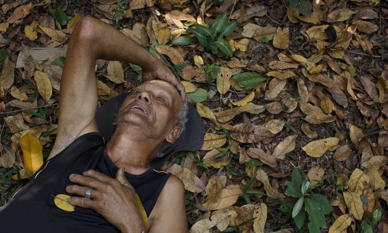 Seu Arnaldo descansa deitado sobre folhas durante percurso de subida para o seu sítio Foto: Daniel Marenco / Agência O Globo