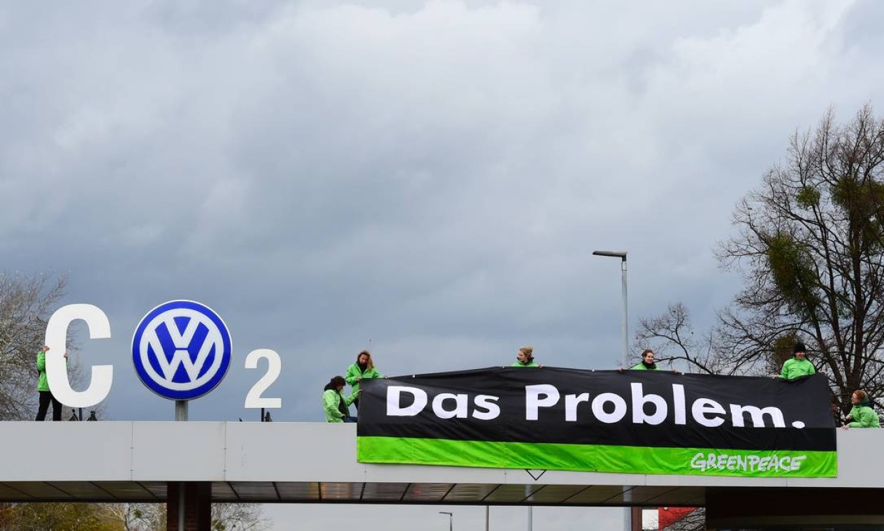 Ativistas do Greenpeace protestam na entrada da fábrica da Volkswagen (VW) em Wolfsburg, região central da Alemanha, em 9 de novembro de 2015. A associação de consumidores da Alemanha quer que a gigante automotiva Volkswagen ofereça vouchers como forma de compensação aos clientes alemães afetados pelo escândalo maciço de fraude na fiscalização de poluentes emitidos pelos veículos do grupo Foto: JOHN MACDOUGALL / AFP