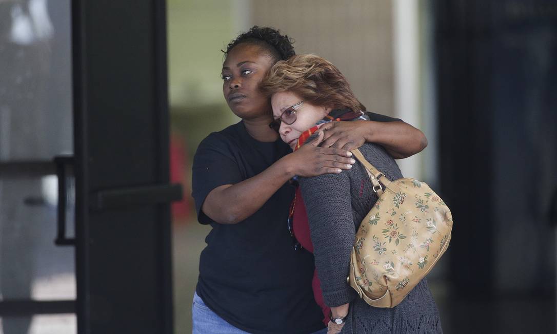 Apreensão. Duas mulheres se abraçam em um centro comunitário que recebeu famílias das vítimas em San Bernardino: questão divide mesmo os partidos Foto: Jae C. Hong / AP