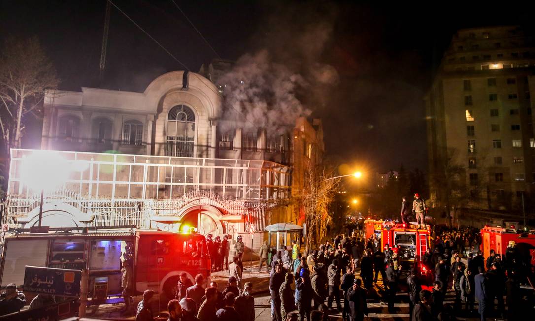 
Bombeiros combatem o fogo ateado em anexo da embaixada da Arábia Saudita em Teerã enquanto policiais se ocupam em dispersar os manifestantes
Foto:
AFP/ATTA KENARE
