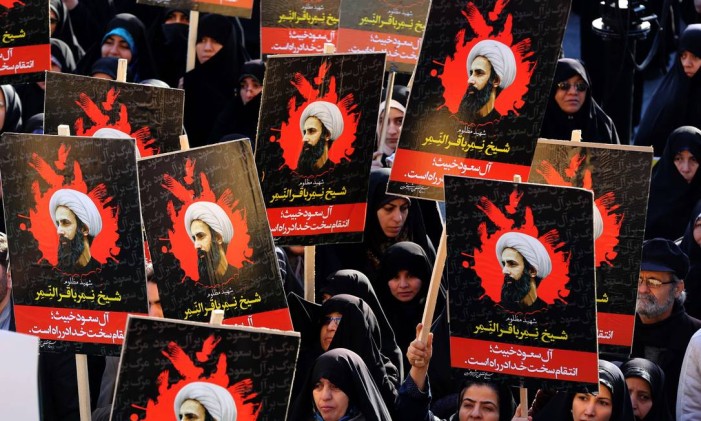 Mulheres iranianas em Teerã protestam contra execução do clérigo Nimr al-Nimr (nos retratos) pelas autoridades sauditas Foto: ATTA KENARE / AFP