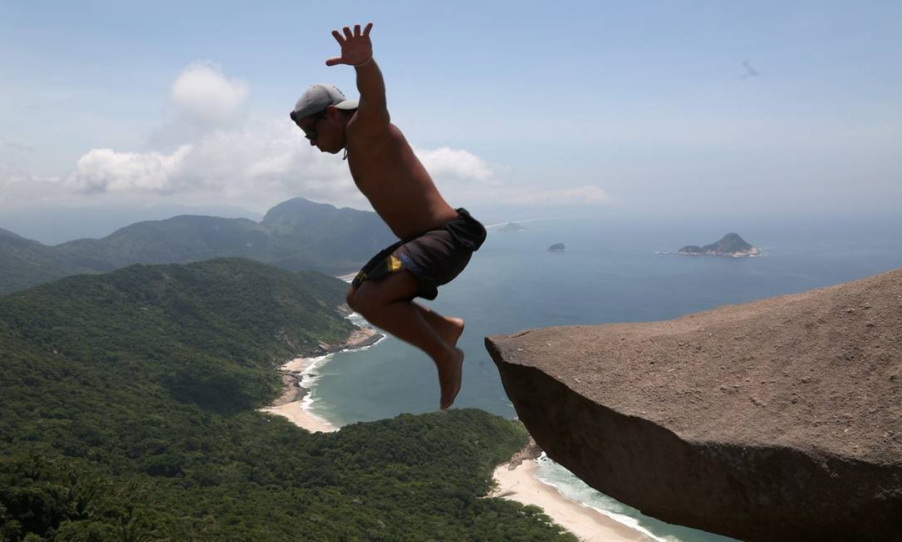 Rafael Dias, de 22 anos, foi mais ousado: pulou da pedra, mesmo com risco de acidente. Vale tudo por uma foto nunca postada antes no Instagram Foto: Custódio Coimbra / Agência O Globo