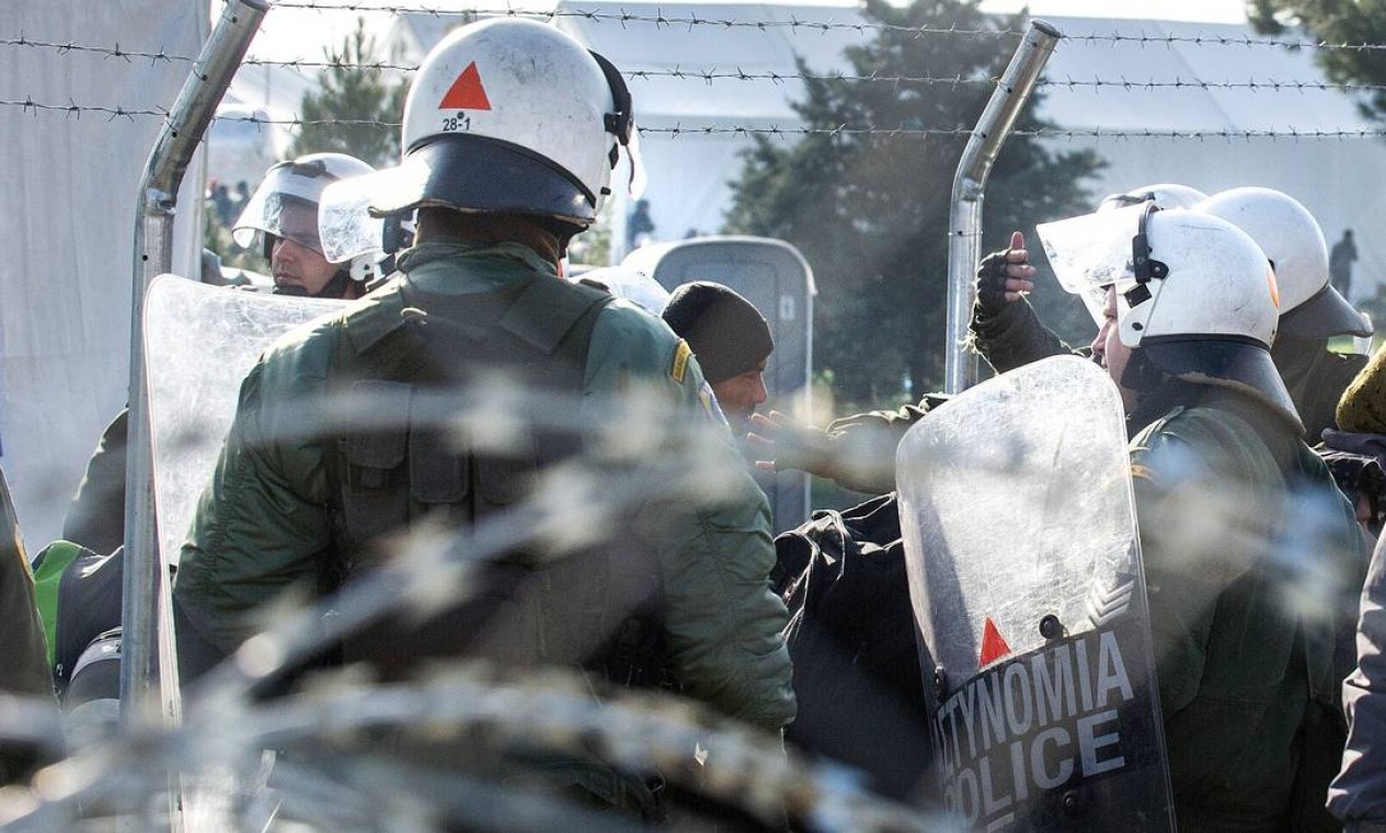 Policiais gregos removem afegãos da linha que divide a Grécia e a Macedônia Foto: ROBERT ATANASOVSKI / AFP