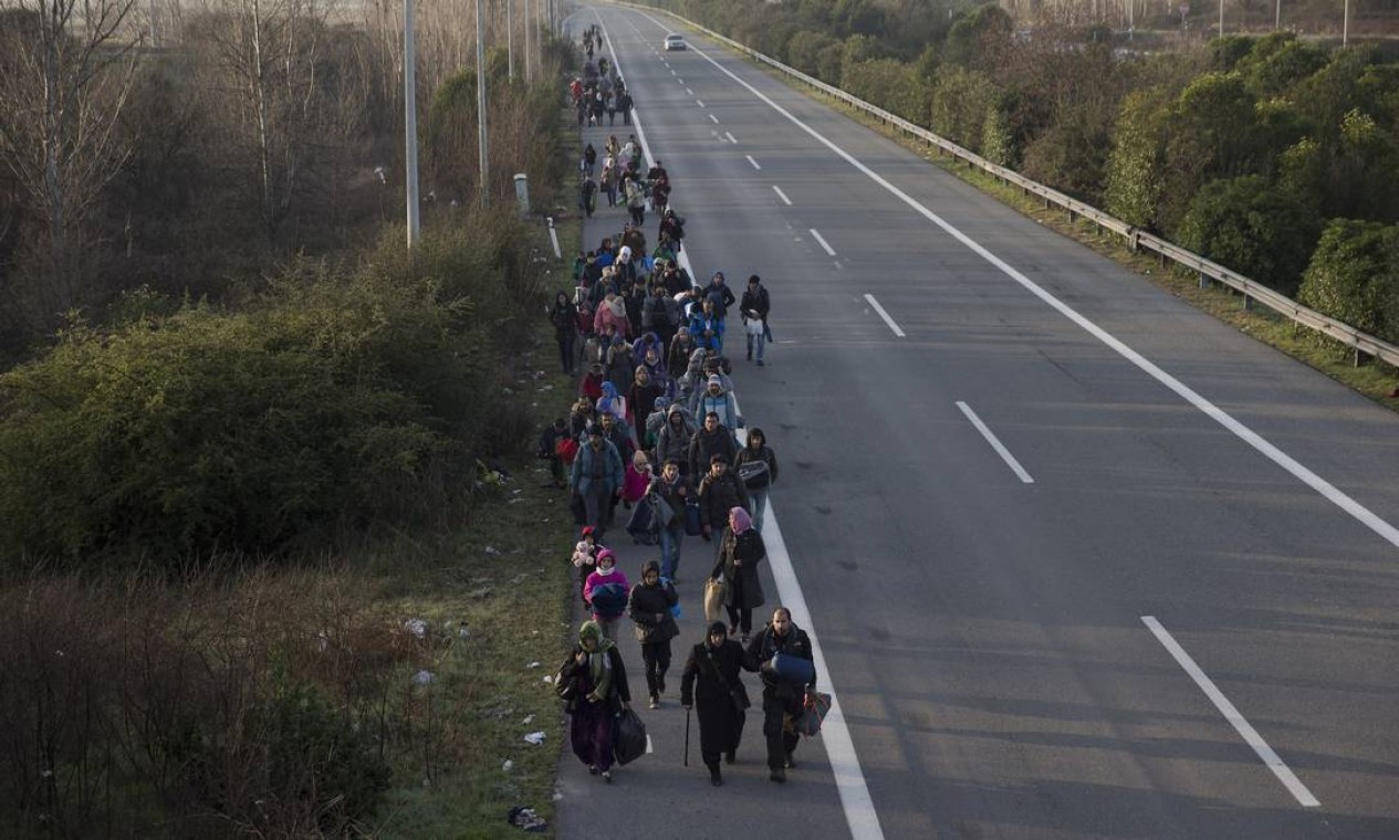 Imigrantes caminham até a fronteira com a Macedônia. A polícia grega removeu centenas de imigrantes do campo após um protesto que paralisou o transporte ferroviário de mercadorias da Macedônia para outros países dos Bálcãs Foto: Petros Giannakouris / AP
