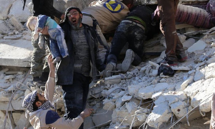 Civis ajudam equipes de resgate a remover criança dos escombros e procurar outras vítimas de bombardeio aéreo do governo sírio, em Aleppo Foto: BARAA AL-HALABI / AFP