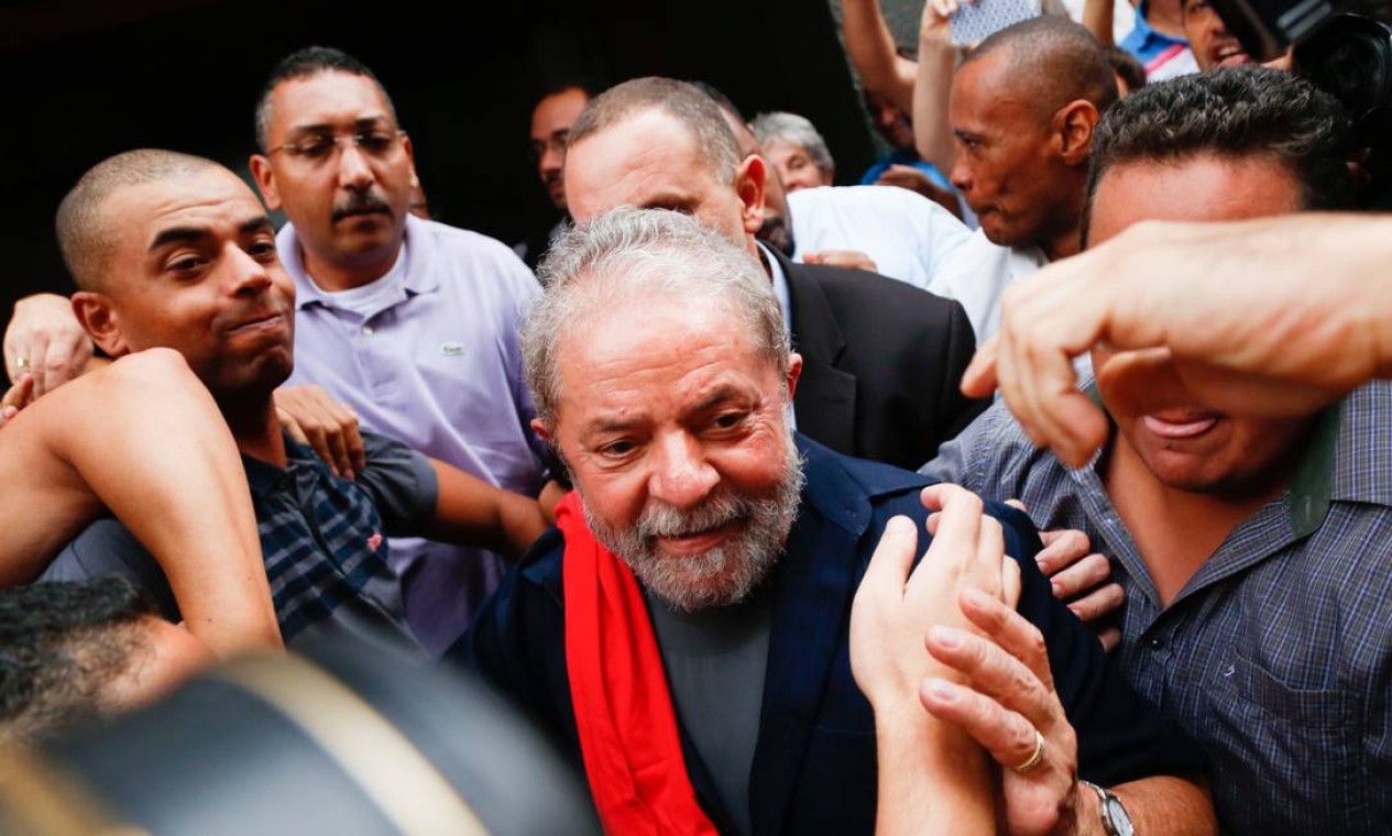 O ex-presidente Lula é cercado por petistas na chegada ao diretório do PT, após prestar depoimento na Polícia Federal, em São Paulo Foto: Edilson Dantas / Agência O Globo