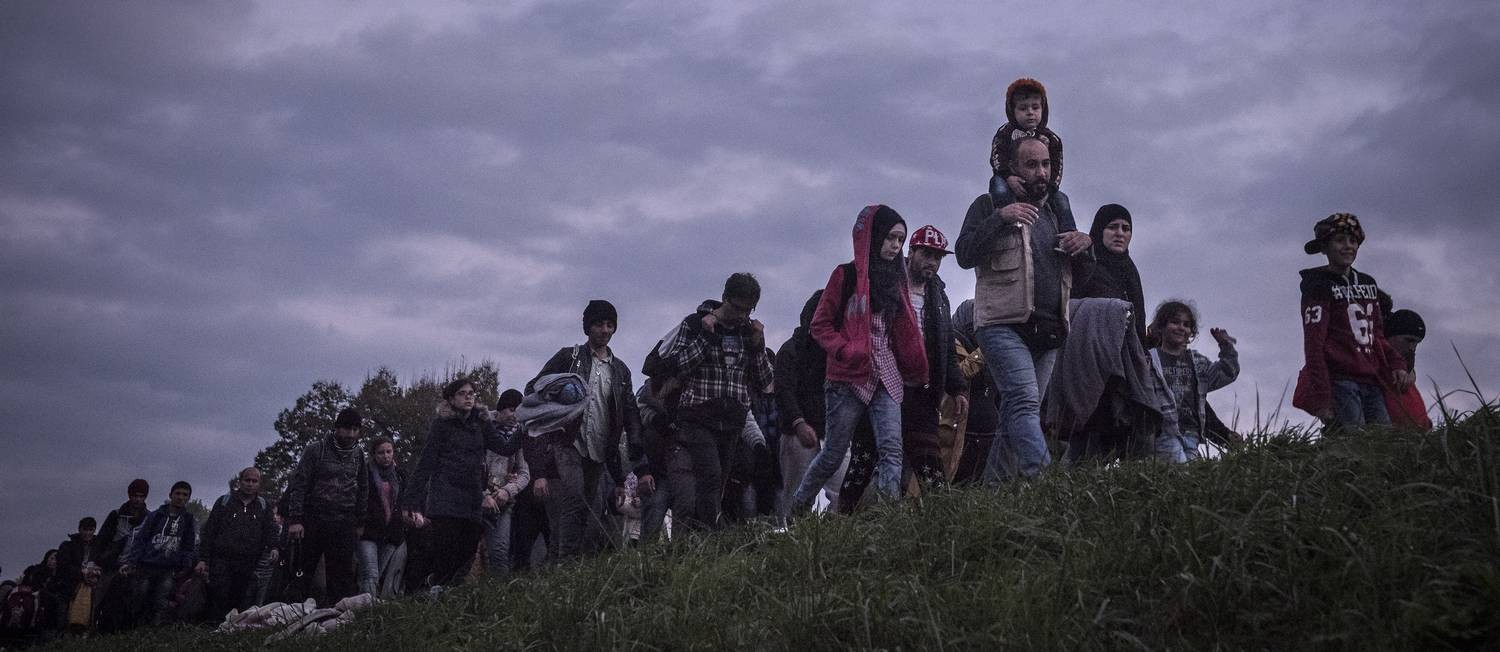 Imigrantes são escoltados pela polícia eslovena, caminhando ao território alemão: com crise geral na Síria, centenas de milhares saem rumo à Europa Foto: SERGEY PONOMAREV / NYT