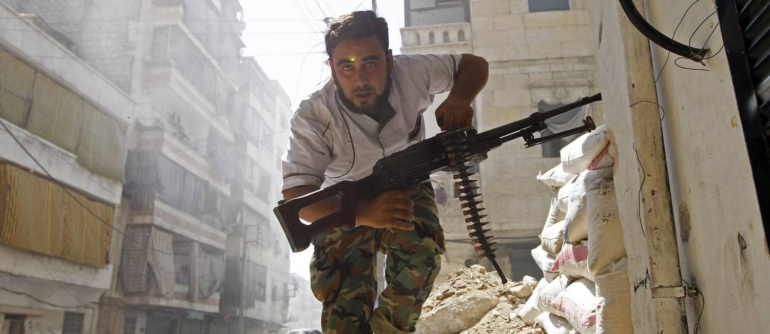 Rebelde do Exército Livre Sírio foge de bombardeios e tiros das Forças Armadas de Bashar al-Assad Foto: GORAN TOMASEVIC / REUTERS