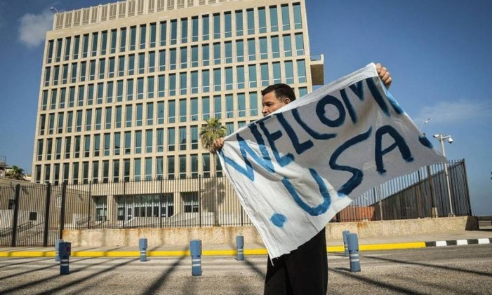 Homem balança cartaz que diz “Bem vindos, Estados Unidos” em frente à embaixada dos EUA em Havana Foto: AFP