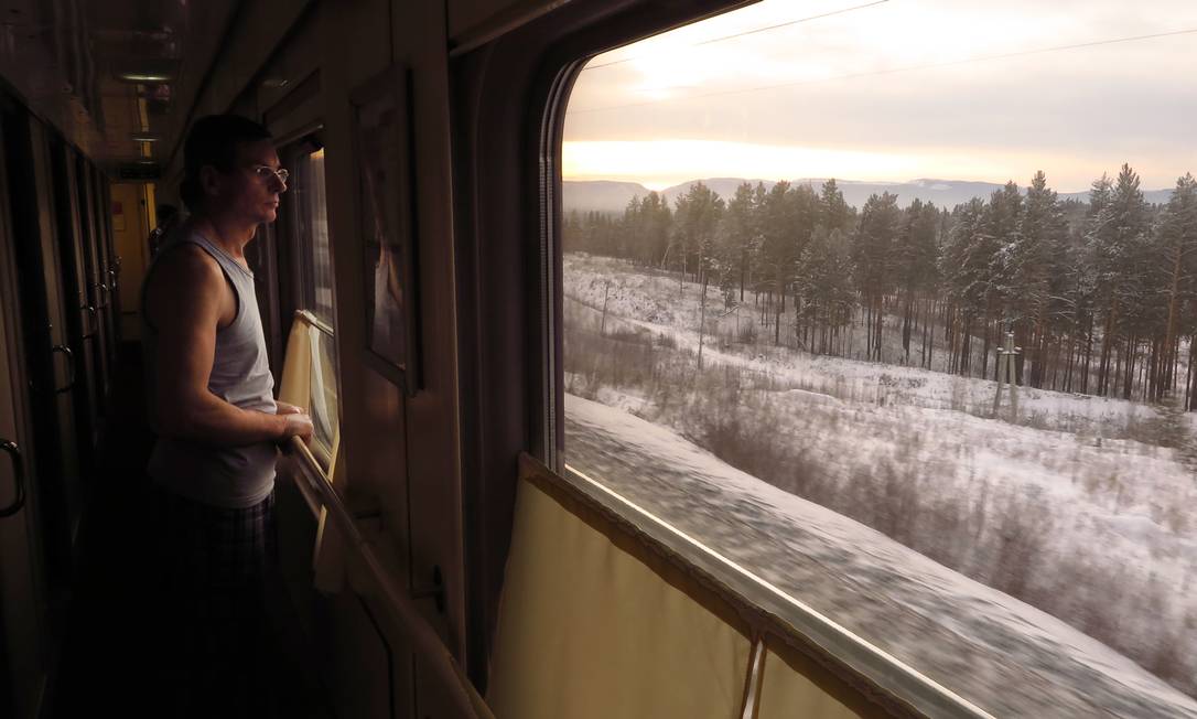 Passageiro observa a paisagem no trem da Transiberiana: viagem é imersão na paisagem e cultura russas Foto: Juarez Becoza / .