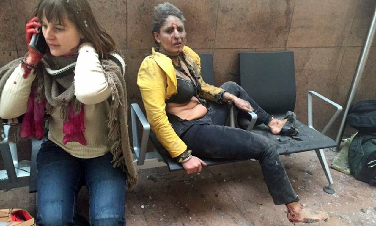 Duas mulheres aguardam atendimento após explosão no aeroporto de Bruxelas Foto: AP