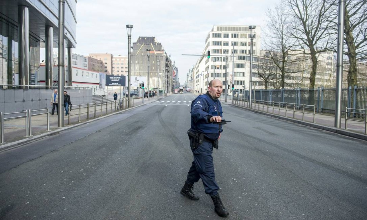 Policial monta guarda na rua de La Loi, em Bruxelas, após a evacuação da estação de metro Maalbeek atingida por uma explosão Foto: LAURIE DIEFFEMBACQ / AFP