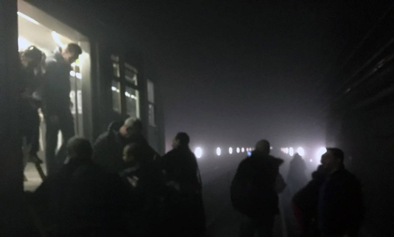 Passageiros deixam os trens e caminham pelos trilhos do metrô da capital belga logo após os atentados à bomba em séria que elevaram o nível de vigilancia em toda a Europa Foto: Evan Lamo / AP