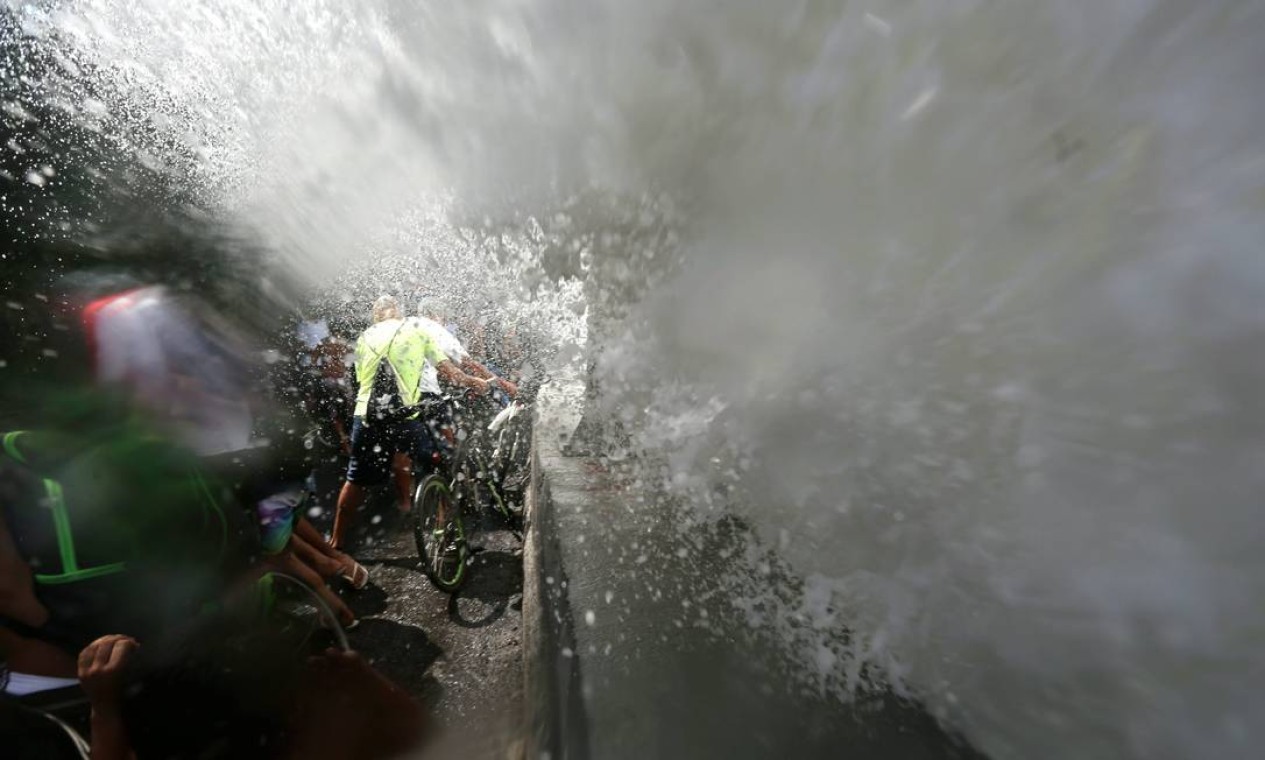 Ciclistas são molhados por onda na ciclovia da Avenida Niemeyer Foto: Custódio Coimbra / O Globo