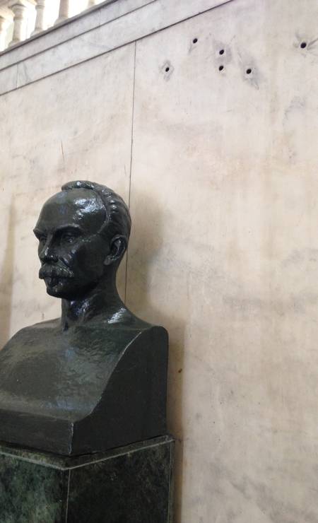 Marcas de balas, disparadas durante a invasão dos combatentes à sede do então governo, estão na parede do Museu da Revolução. À frente, busto do mártir da independência cubana Foto: Léa Cristina / O GLOBO