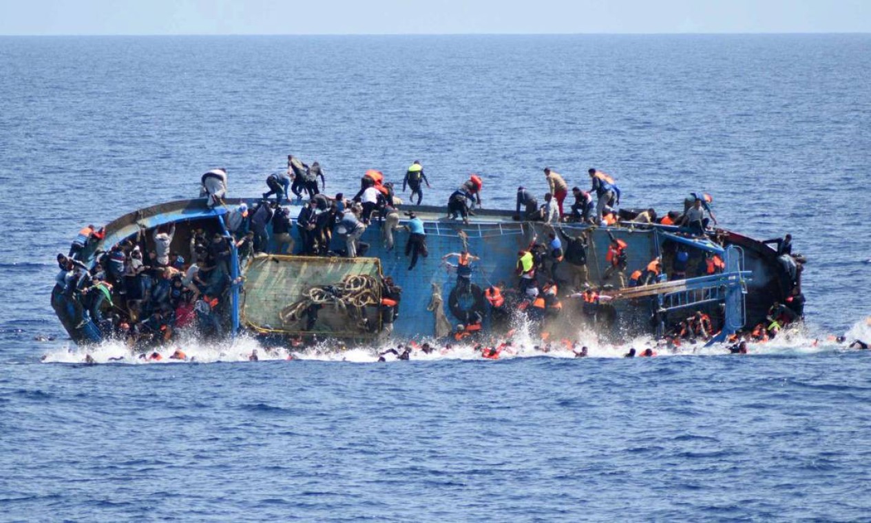 A embarcação vira: pelo menos cinco pessoas se afogaram. Outras 500 foram resgatadas por navios da Marinha italiana Foto: STR / AFP