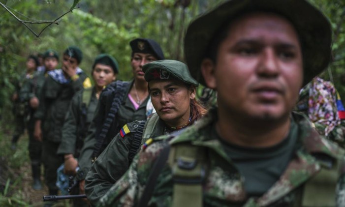 Membros das FARC marcham nas proximidades de um acampamento nas montanhas da Colômbia Foto: FEDERICO RIOS ESCOBAR / NYT