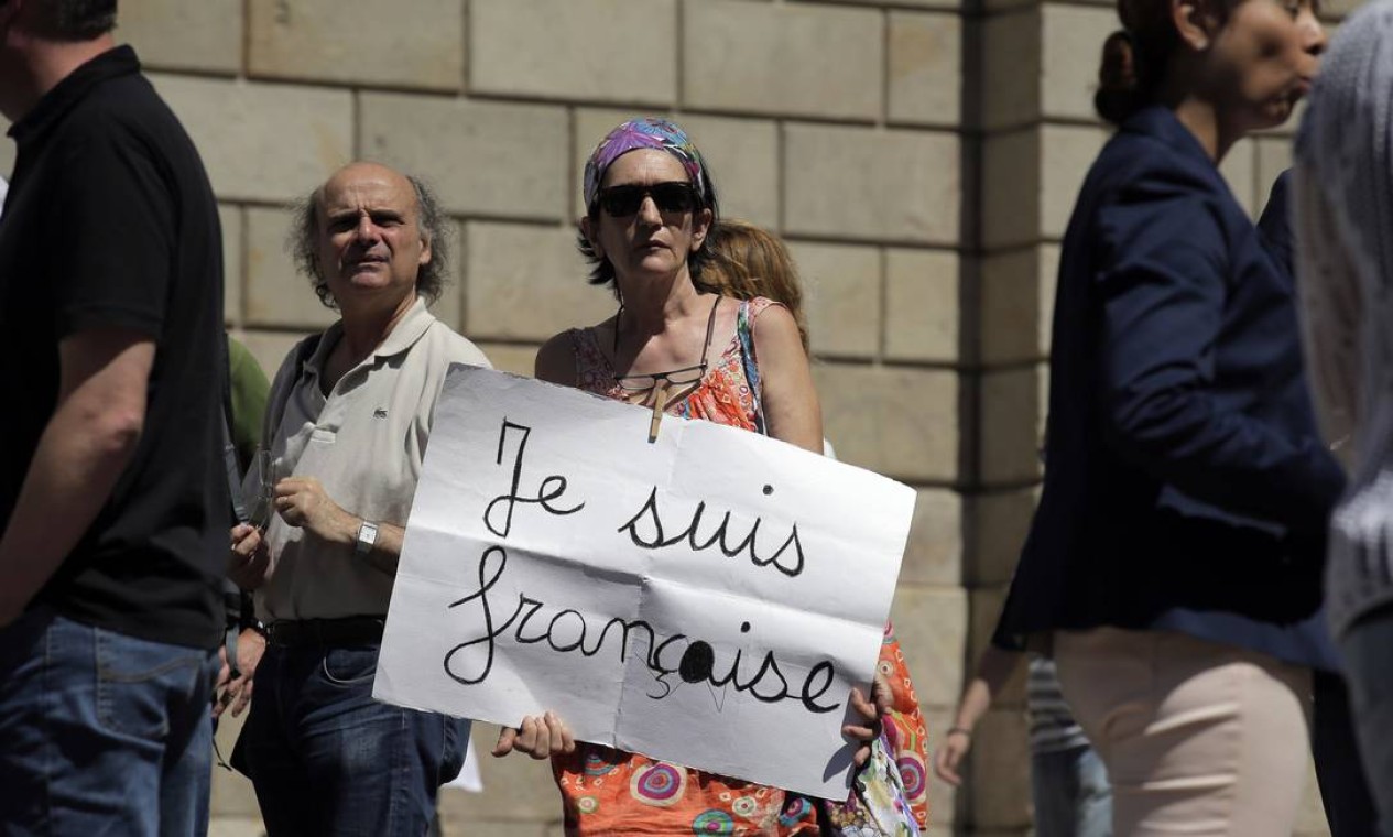 Uma mulher segura um papel onde se lê: "Eu sou francesa". Uma homenagem aos mortos e feridos no ataque ocorrido em Nice no dia 14 de julho Foto: Manu Fernandez / AP