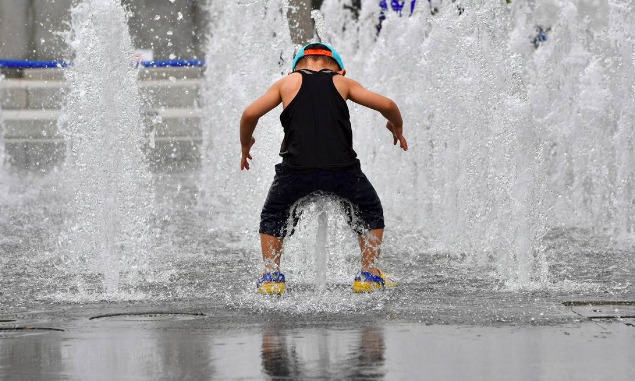 Um menino se refresca em dia dia de forte calor, em Seul Foto: JUNG YEON-JE / AFP