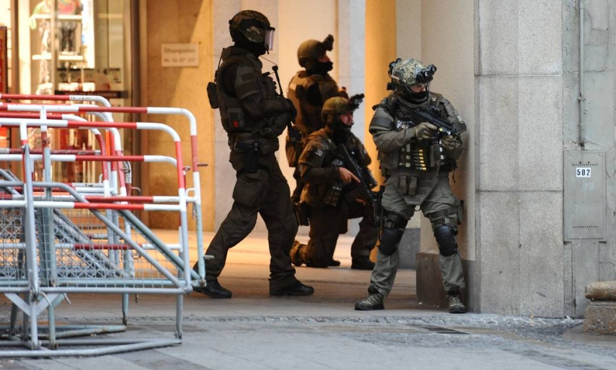 Políciais tomam posição próximo à entrada do shopping, onde várias pessoas foram mortas durante a ação de um atirador, em Munique, na Alemanha Foto: ANDREAS GEBERT / AFP
