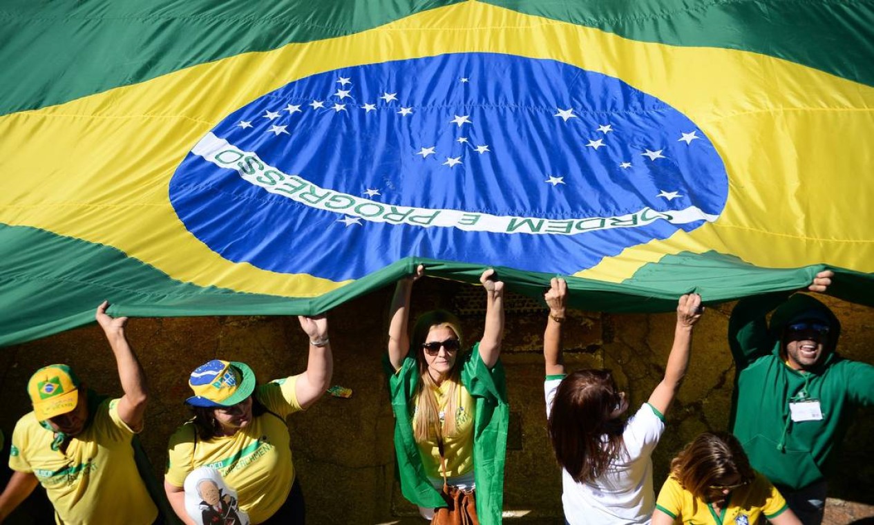 Manifestantes carregam uma grande bandeira do Brasil durante o ato Foto: ANDRESSA ANHOLETE / AFP