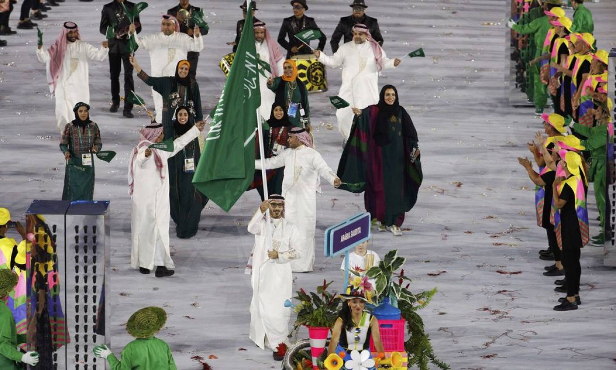 Arábia Saudita desfilou com quatro atletas mulheres à frente, fato inédito na História dos Jogos. O porta-bandeira é Sulaiman Hamad Foto: STOYAN NENOV / REUTERS