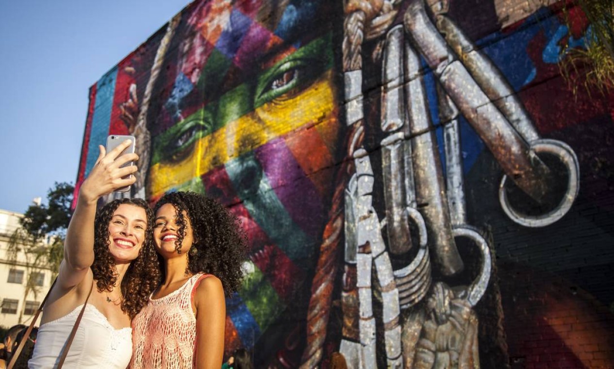 O mural de Eduardo Kobra é fundo para diversas 'selfies' Foto: Hermes de Paula / Agência O Globo