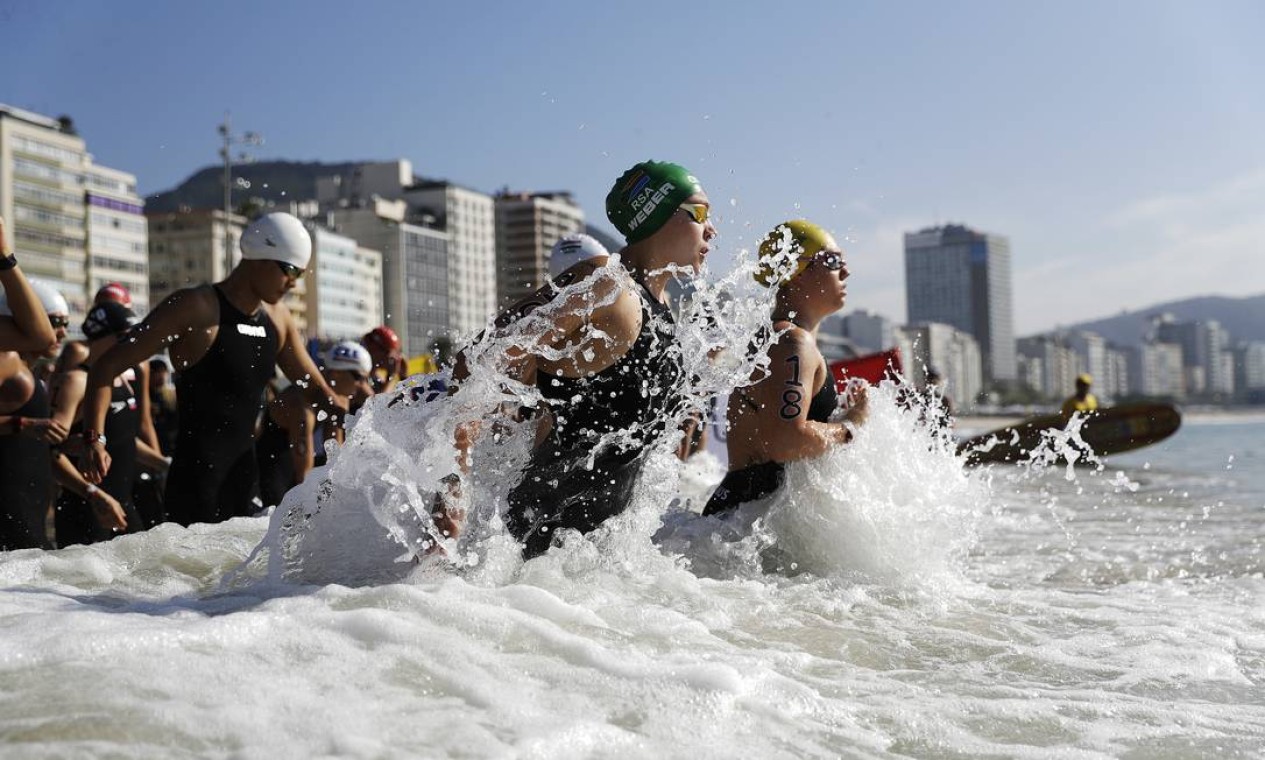 Michelle Weber , da África do Sul, de touca verde, entra no mar junto com outras competidoras Foto: David Goldman / AP