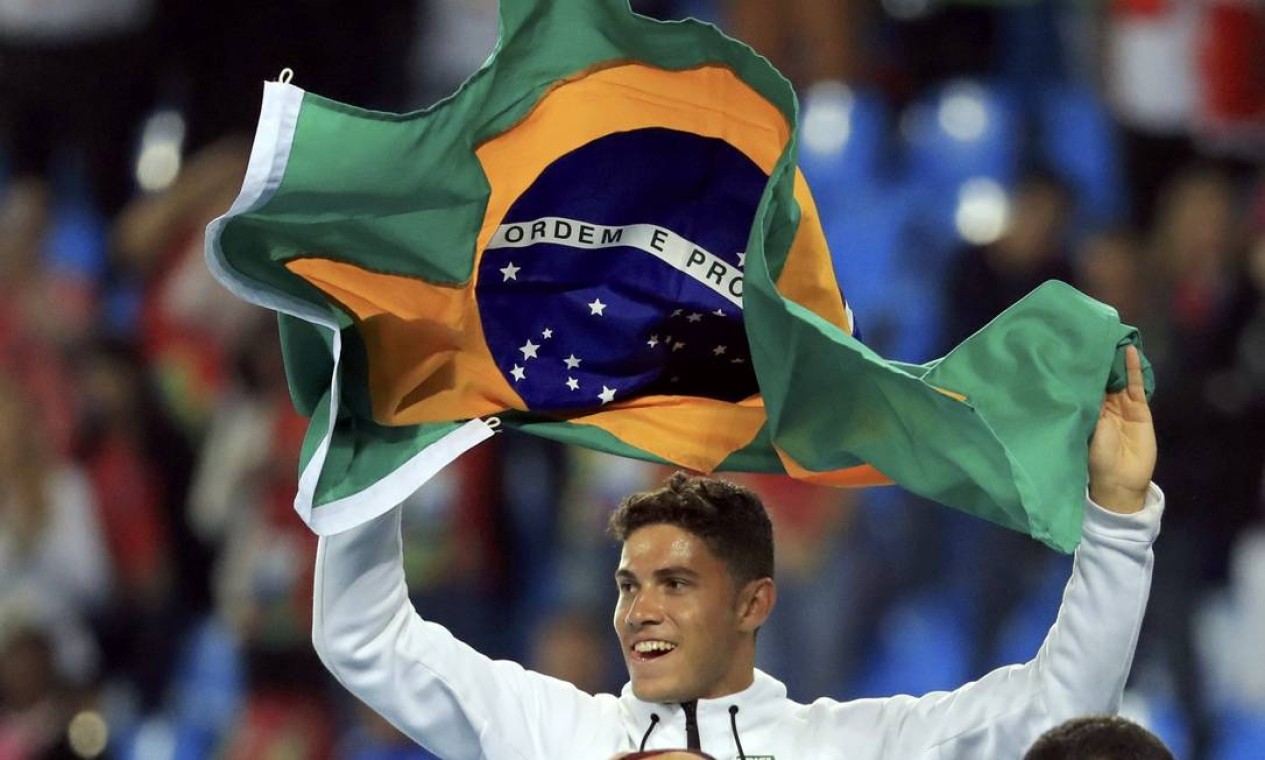 Carregando a bandeira brasileira Thiago faz a torcida delirar no Engenhão Foto: DOMINIC EBENBICHLER / REUTERS