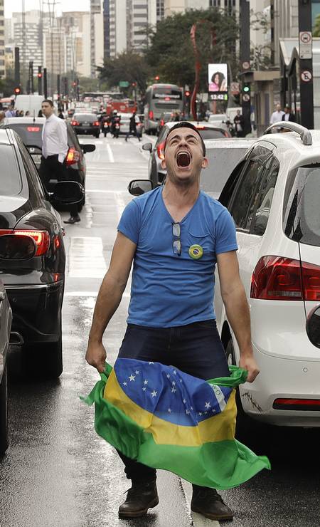 Homem se arrisca entre carros para comemorar o impeachment Foto: Andre Penner / AP