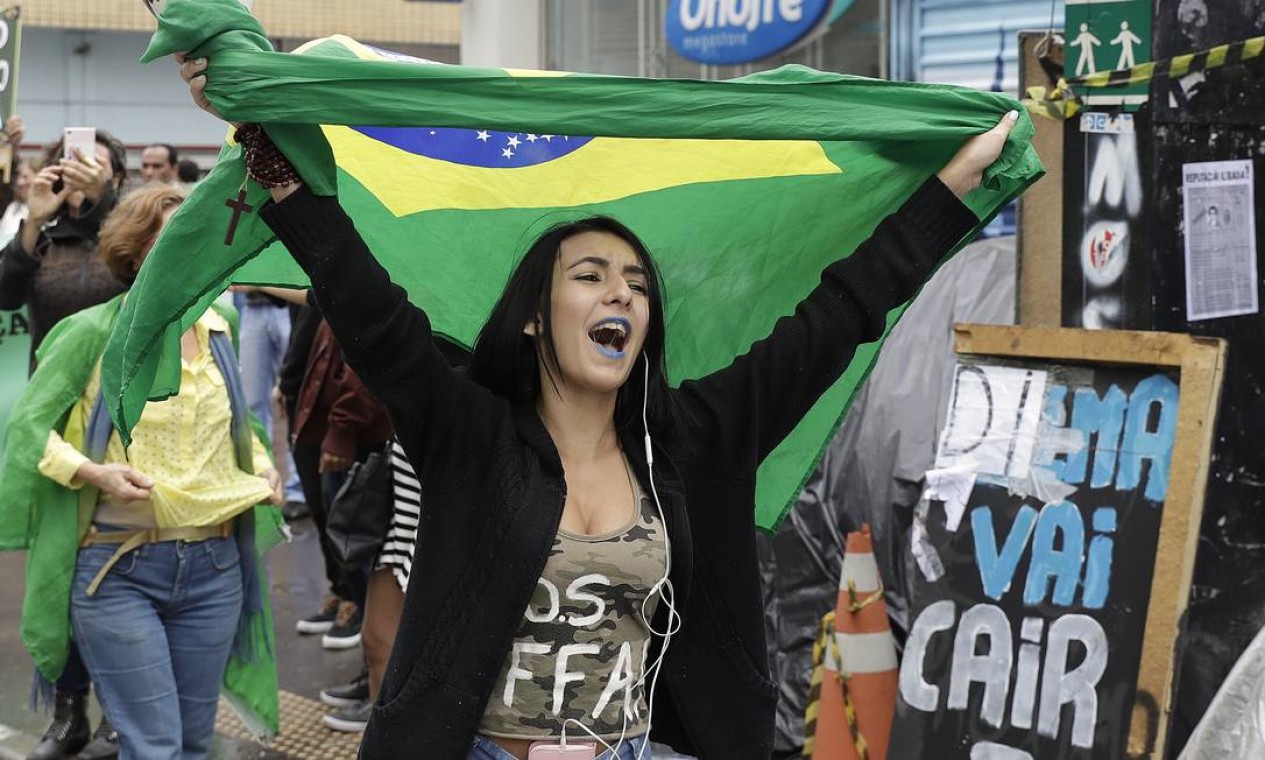 Militante pró-impeachment exibe bandeira do Brasil após o fim da decisão de depor a presidente Foto: Andre Penner / AP