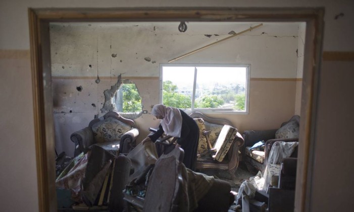 Mulher palestina checa os danos em sua casa na cidade de Beit Hanoun Foto: Khalil Hamra / AP