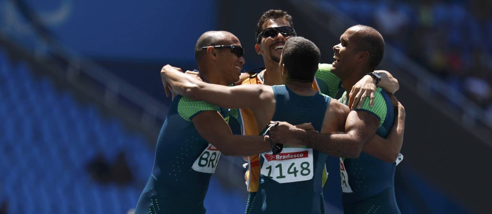 Um dos dois guias e três dos quatro corredores da equipe brasileira de revezamento festejam o ouro no 4x100m da classe T11-13 Foto: RICARDO MORAES / REUTERS