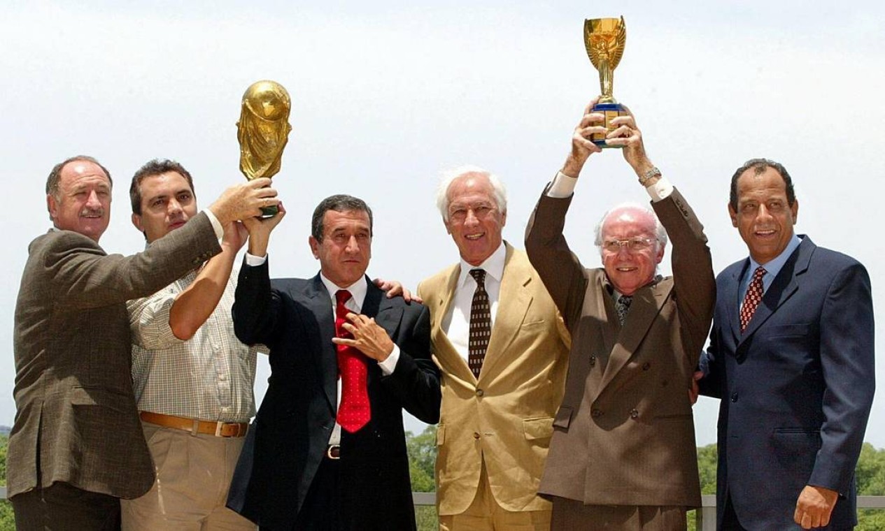 Em 2002, Carlos Alberto Torres (último à direita) posa com Bellini e Branco, capitães que também levantaram Copas do Mundo, e com os então treinadores Felipão, Parreira e Zagallo: comemoração pelo penta Foto: Antonio Scorza / AFP