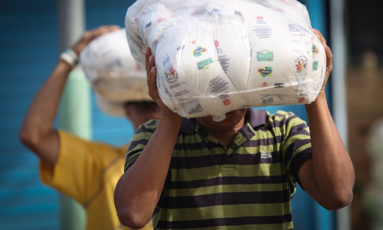 Durante o dia, os imigrantes trabalham descarregando carretas com mercadorias que chegam de Boa Vista Foto: Marcos Alves / Agência O Globo
