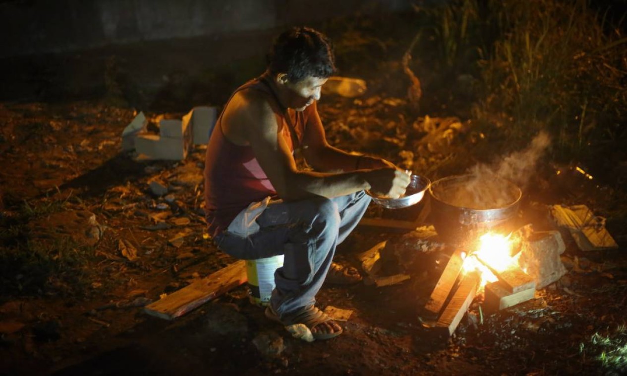 Um grupo de indígenas veio para o Brasil tentar conseguir dinheiro e voltar em 15 dias para casa. A panela de arroz serve dez pessoas Foto: Marcos Alves / Agência O Globo