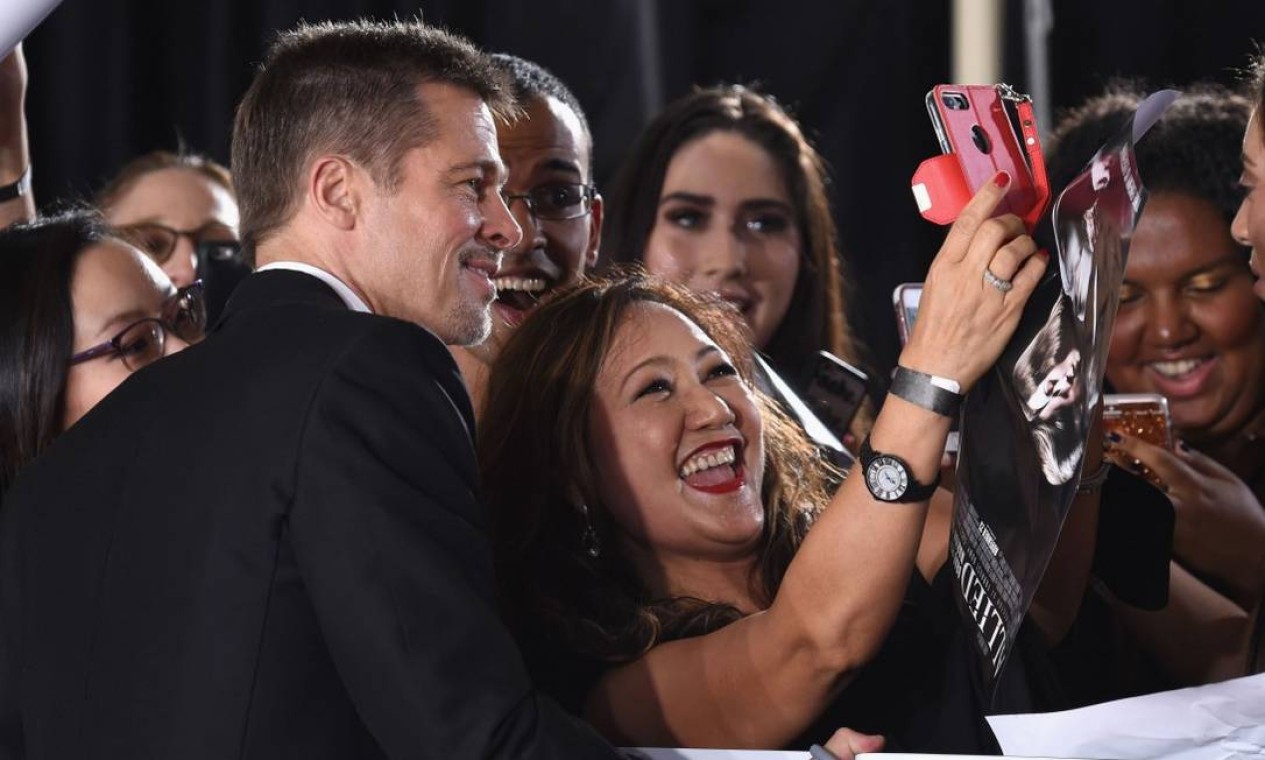 Apesar dos problemas pessoais, Brad Pitt fez questão de ser solícito tirar selfies com os fãs Foto: Frazer Harrison / AFP