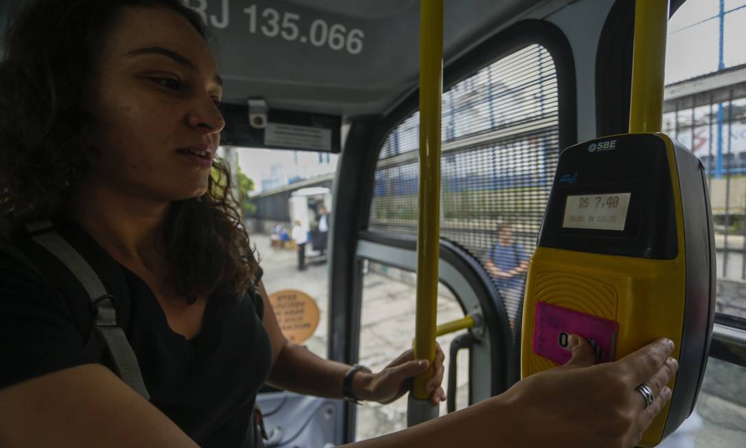 Passageira paga o valor integral da tarifa de ônibus intermunicipal em Niterói Foto: Gabriel de Paiva / O Globo