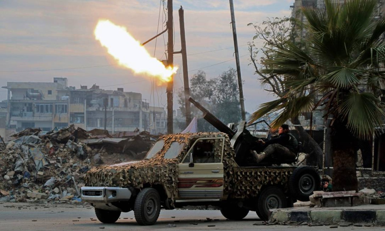 Combatentes do Exército Livre da Síria disparam arma contra aviões militares no bairro de Mashhad, em Aleppo Foto: STRINGER / AFP