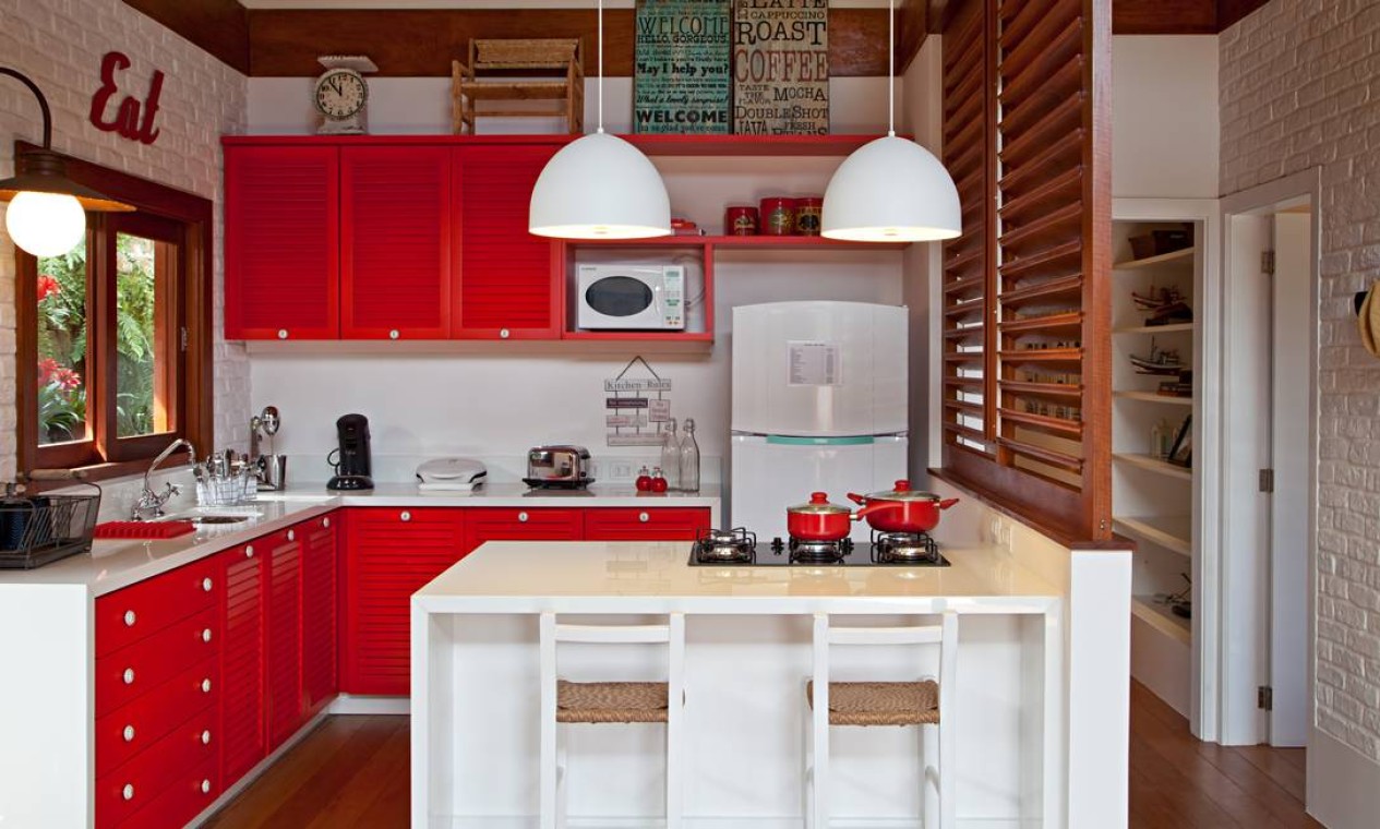 O vermelho nas portas de armários e gavetas aquece a cozinha projetada por Maurício Nóbrega Foto: Rodrigo Azevedo / Divulgação