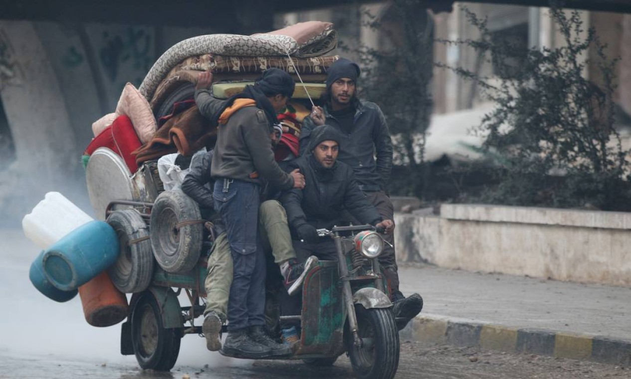 Homens levam pertences em triciclo enquanto fogem de áreas rebeldes durante ofensiva das tropas do regime sírio em Aleppo Foto: ABDALRHMAN ISMAIL / REUTERS