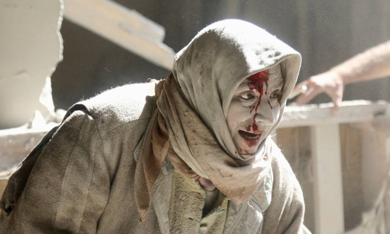 Mulher ferida fica coberta de poeira após ataque aéreo em bairro rebelde de Aleppo, na Síria Foto: ABDALRHMAN ISMAIL / REUTERS